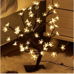 Decorative LED tree with illuminated branches on a soft surface