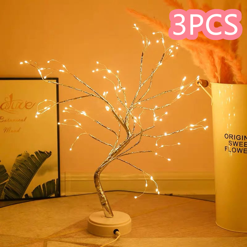 Decorative LED tree with lights on a wooden surface, next to a container labeled '3PCS'.