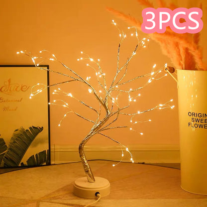 Decorative LED tree with lights on a wooden surface, next to a container labeled '3PCS'.