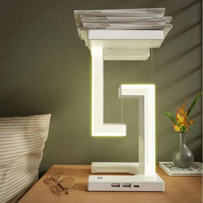 Modern LED table lamp on a wooden surface with books stacked on top, in a room setting.